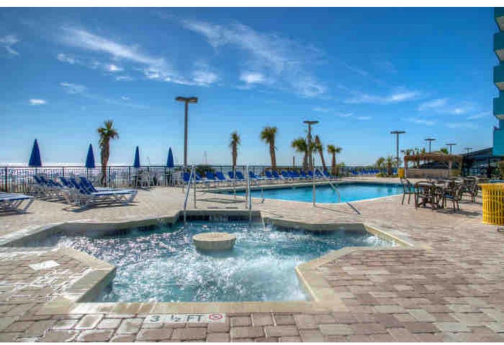 默特尔比奇Upgraded Studio at Landmark Resort ! 17 pools, lazy rivers, jacuzzis! 814的棕榈树和椅子的度假村的游泳池