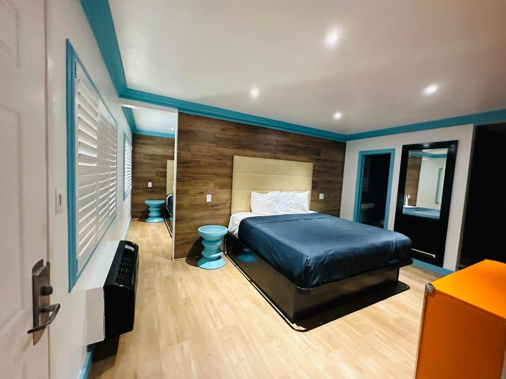惠蒂尔Casa Blanca Inn & Suites Whittier的一间卧室配有一张大床和镜子