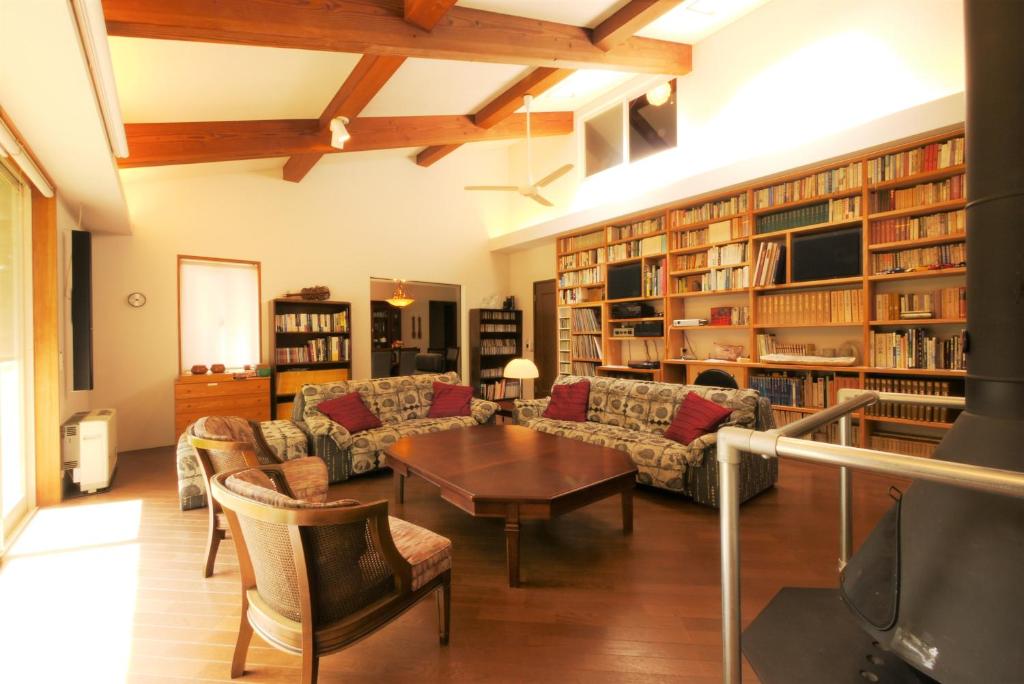鸣泽市スイートヴィラ 河口湖 Mt.Fuji House的客厅配有沙发和桌子