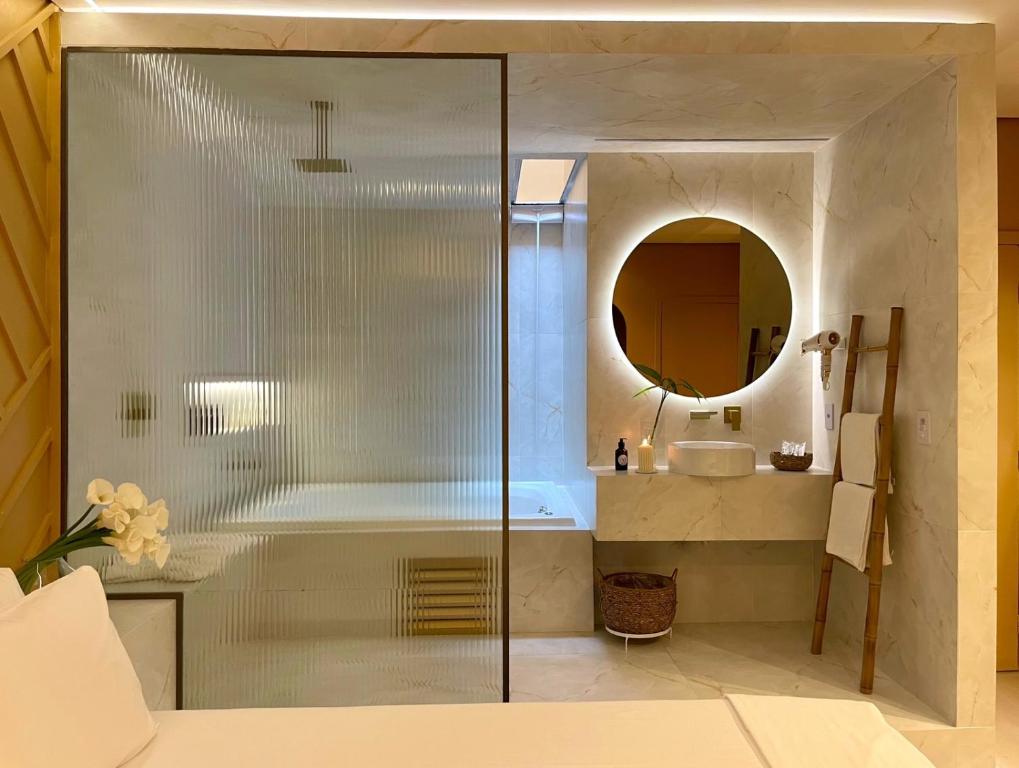 巴西利亚Yolo Motel的带浴缸、水槽和镜子的浴室