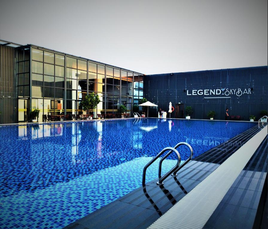 西哈努克Legend Hotel and Resort的大楼前带长凳的游泳池
