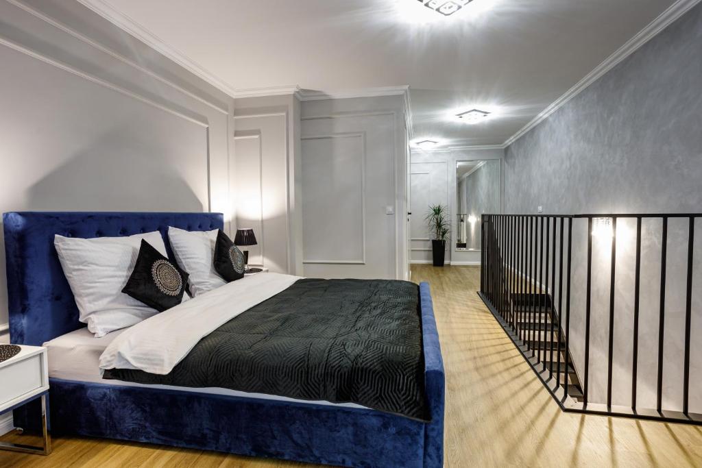 扎莫希奇Luksusowy apartament z sauną的一间卧室配有一张蓝色床头板的大床
