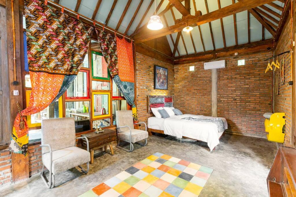 JarakanOmah Dhalang, Ethnic Java House with Nature View的一间卧室设有一张床和砖墙