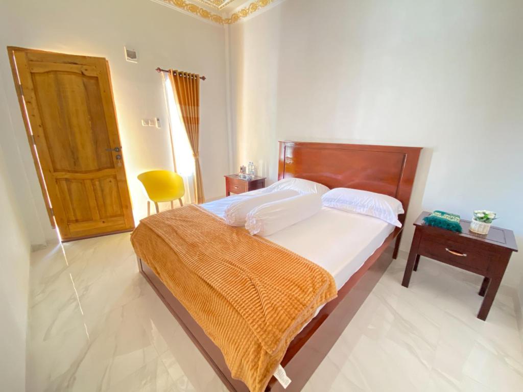 比拉Rumah Windy Guest House Bira的卧室配有床、桌子和门