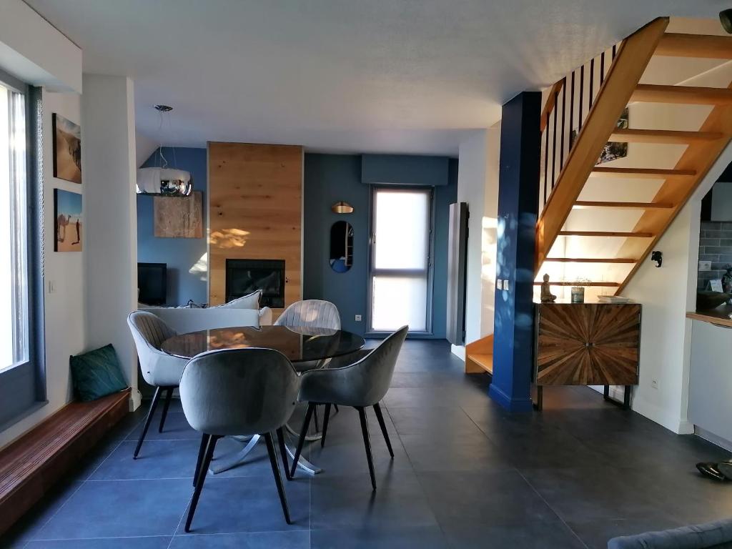 斯特拉斯堡Spacieux loft en duplex的用餐室以及带桌椅的起居室。