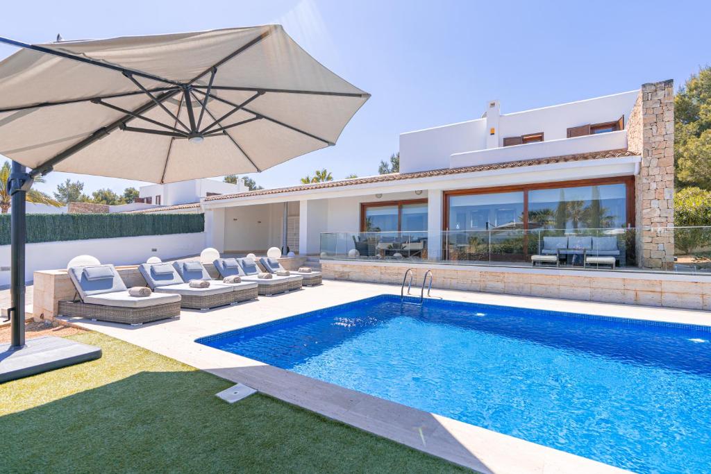 圣何塞德萨塔莱阿Beautiful Villa Bohemia Ibiza的一座带游泳池和遮阳伞的别墅