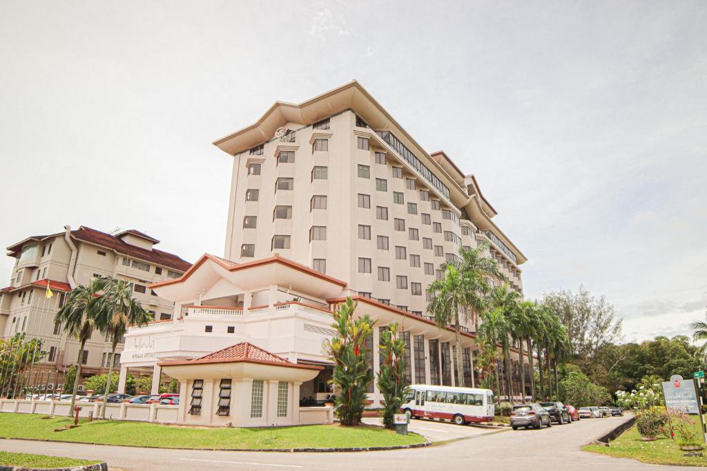斯里巴加湾市辉煌酒店的一条高大的白色建筑,在街道前有棕榈树