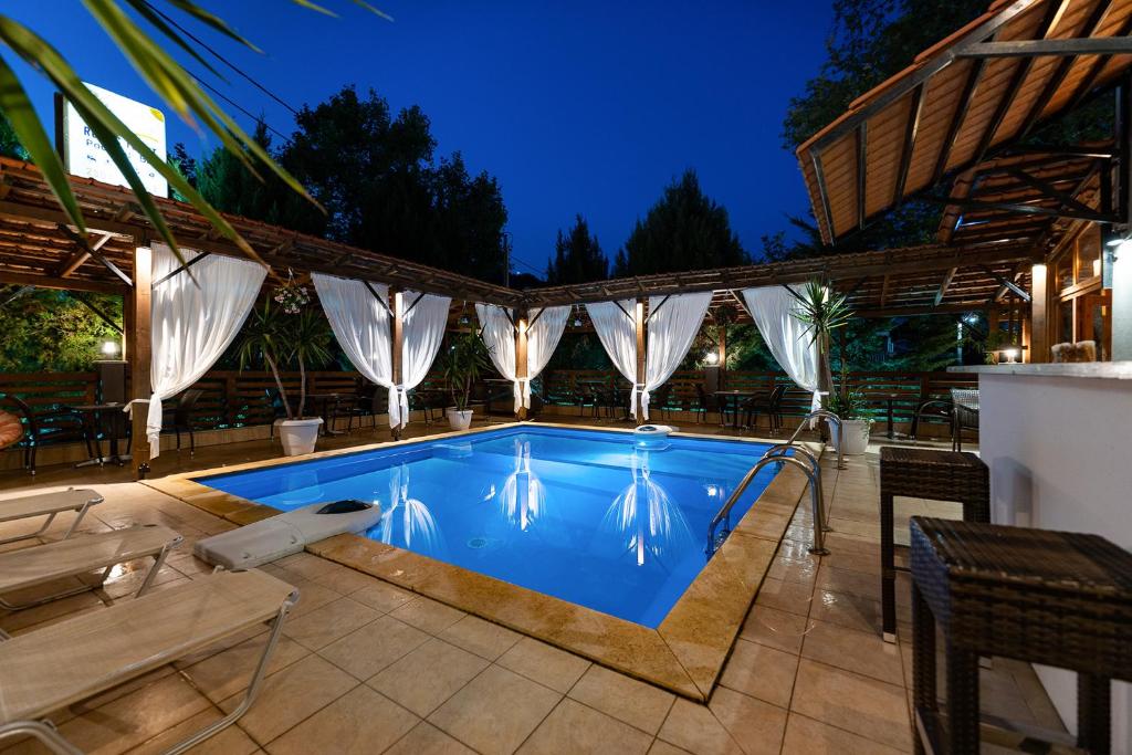尼亚普拉莫斯吉普斯度假酒店的后院的游泳池,配有桌椅