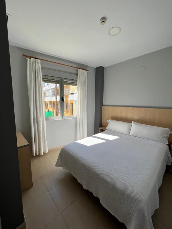 蓬塔翁布里亚曼努埃拉旅馆的卧室设有一张白色大床和一扇窗户。