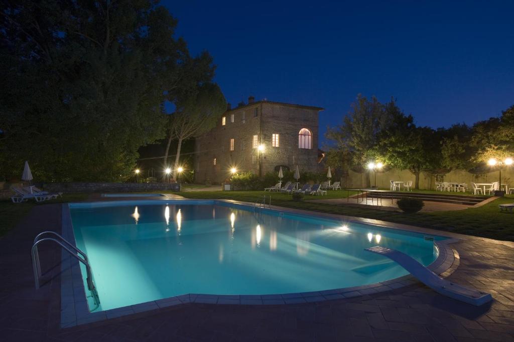 圣罗科阿费力Borgo San Lorenzo a Linari的一座游泳池,在晚上在建筑物前