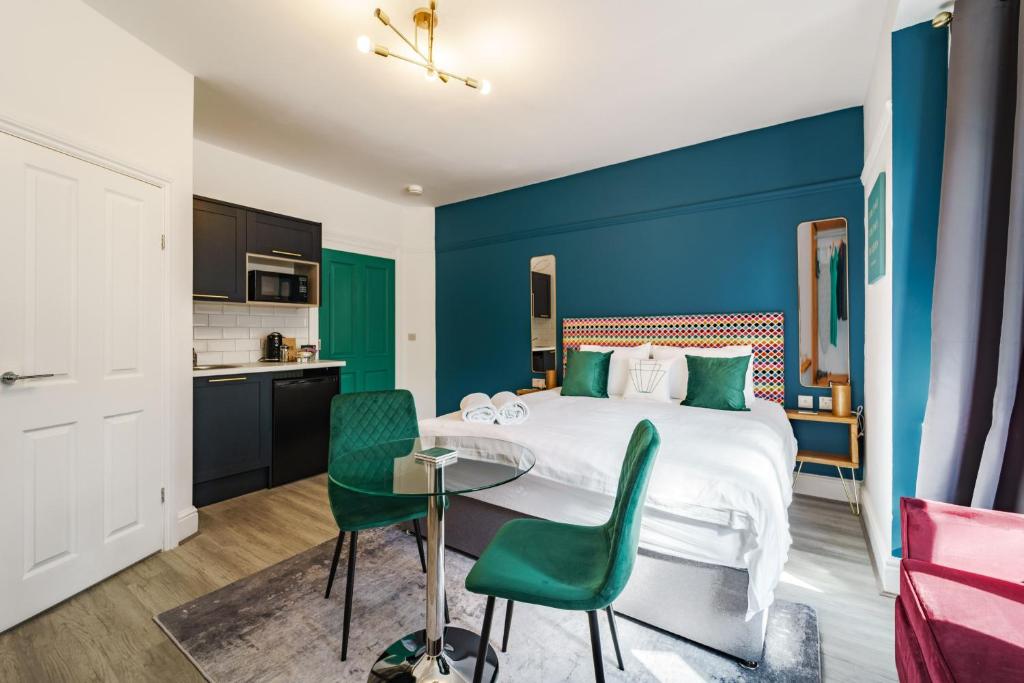 埃文河畔斯特拉特福Emerald Stays UK at The Adelphi的酒店客房带一张床、一张桌子和椅子