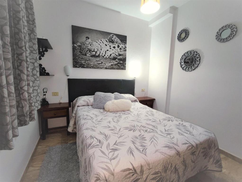 罗萨里奥港Awesome Apartment的卧室配有一张床,墙上挂着一幅画