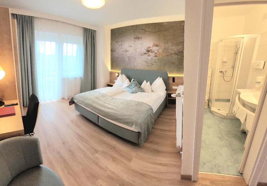 沃尔特湖畔韦尔登格尔尼伍尔泽酒店的一间卧室,卧室内配有一张大床