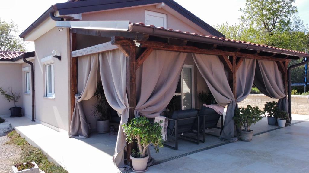 波雷奇Vacation house ''CASA TERRA''的房屋内带遮阳篷和窗帘的天井