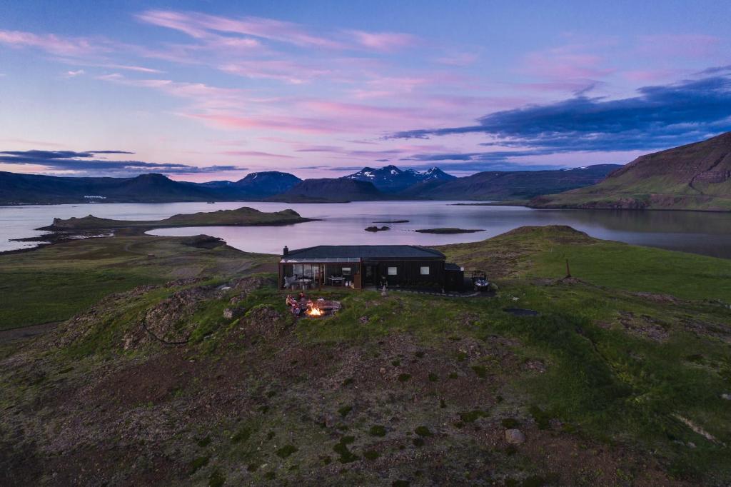KjósahreppurHvammsvík Nature Resort的湖上岛屿上房屋的空中景观