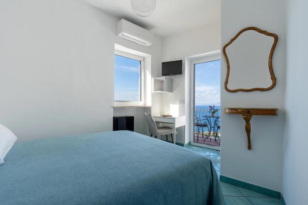 卡普里普罗拉酒店的一间卧室配有一张床、镜子和一张书桌
