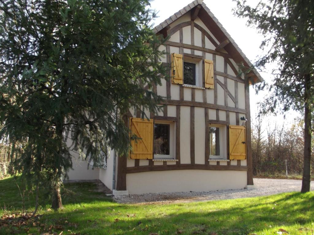 Crouy-sur-CossonLa Haute Bédinière的黄色百叶窗和树的房子