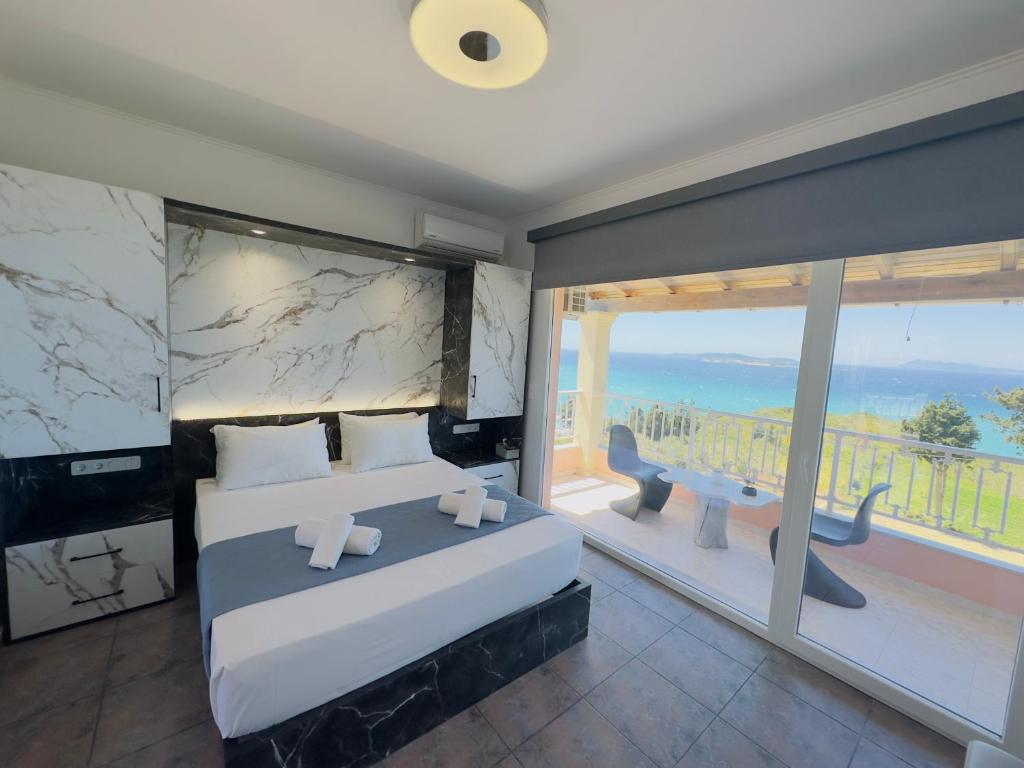 圣斯特凡诺斯Nikos Apartments Corfu的一间卧室设有一张大床和一个大窗户