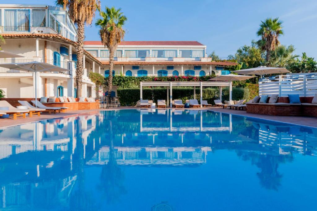 卡塔尼亚乐度纳西西里酒店的棕榈树建筑前的游泳池