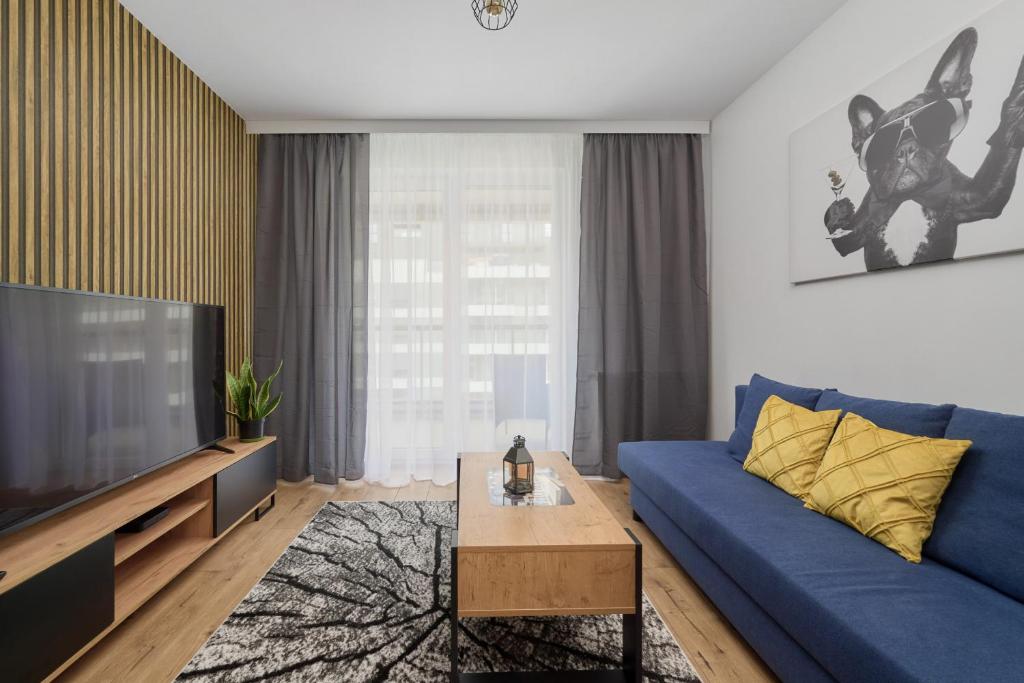 弗罗茨瓦夫Apartment with 2 Bedrooms & Parking Wrocław by Renters的客厅配有蓝色的沙发和电视