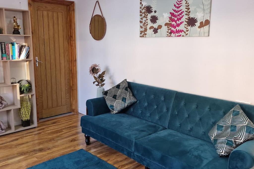 埃尔特姆1 Bedroom Studio的客厅设有蓝色的沙发和门。