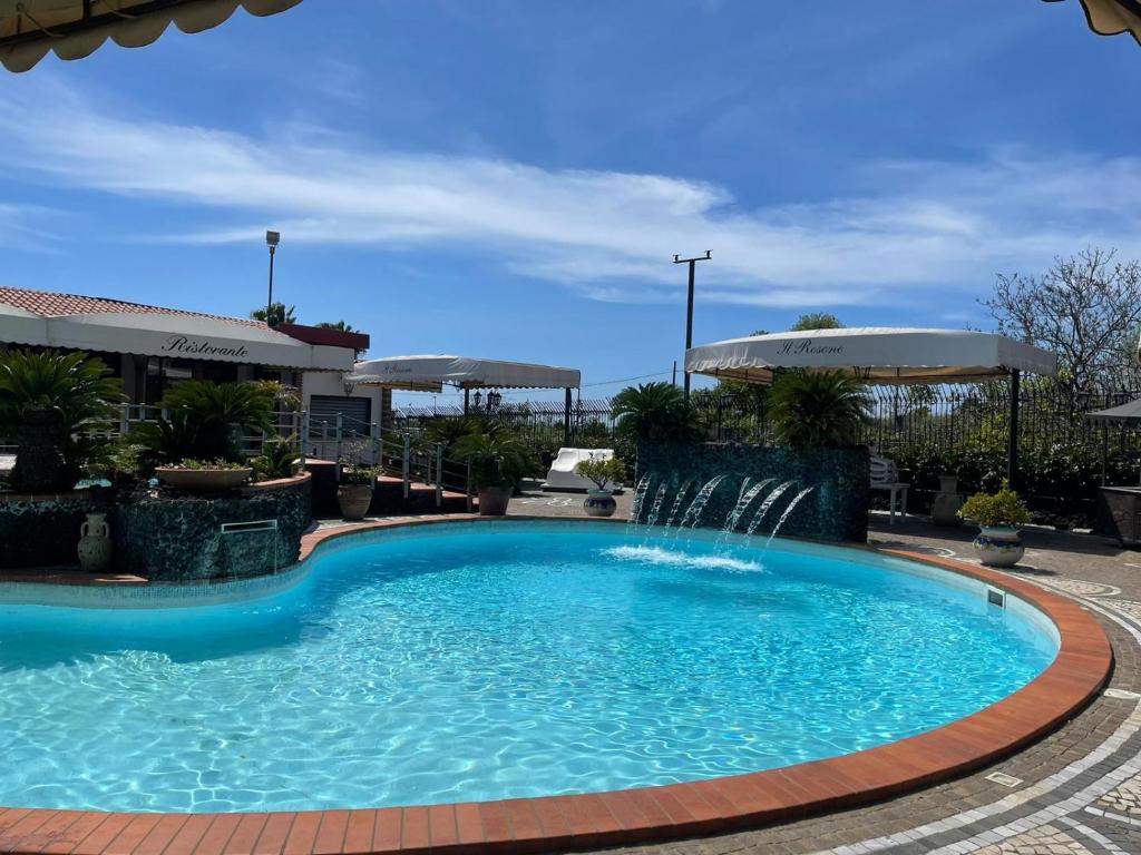 泰卡斯Hotel il Rosone的度假村内带喷泉的游泳池