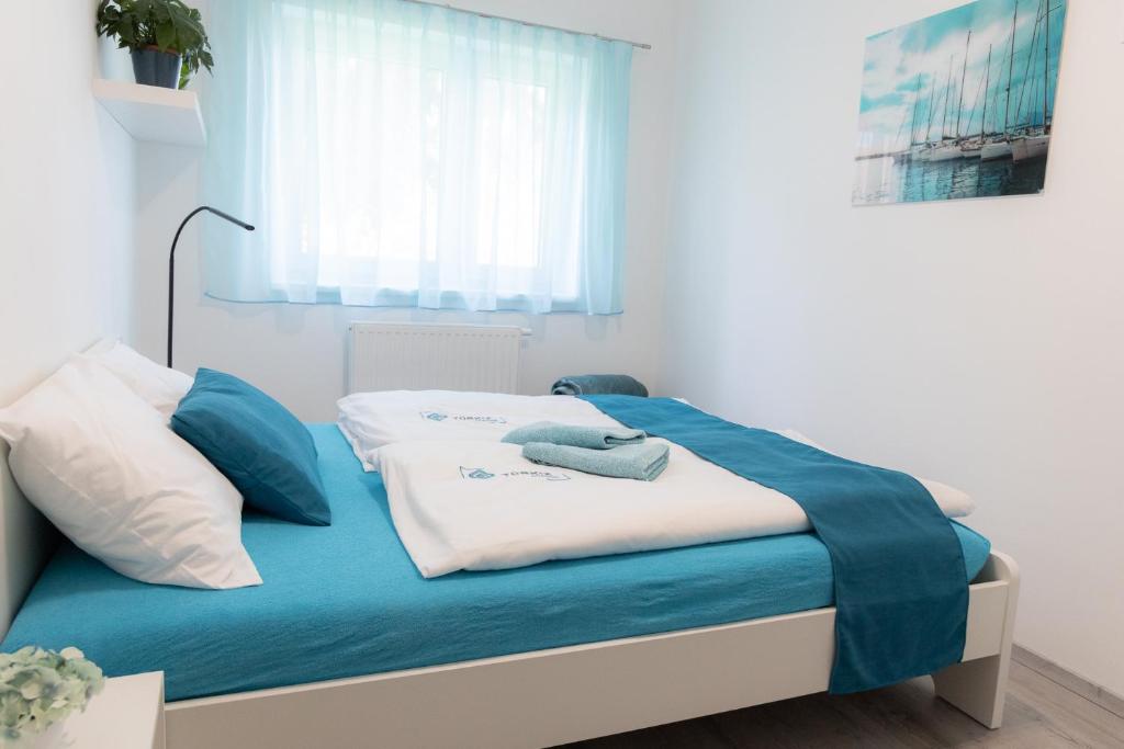克塞洛Türkiz apartman的一间卧室配有蓝色和白色床单