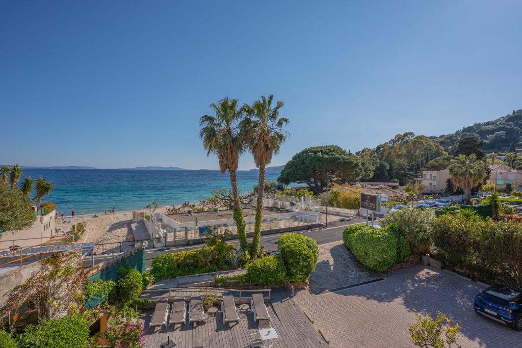 勒拉旺杜格朗帕瓦大酒店的海滩上,有椅子和棕榈树,还有大海