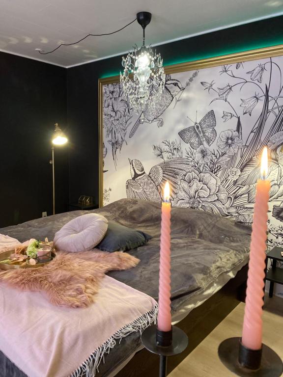 纳克斯考Slava Kongenstofte house的一间卧室配有一张带两张蜡烛的床。