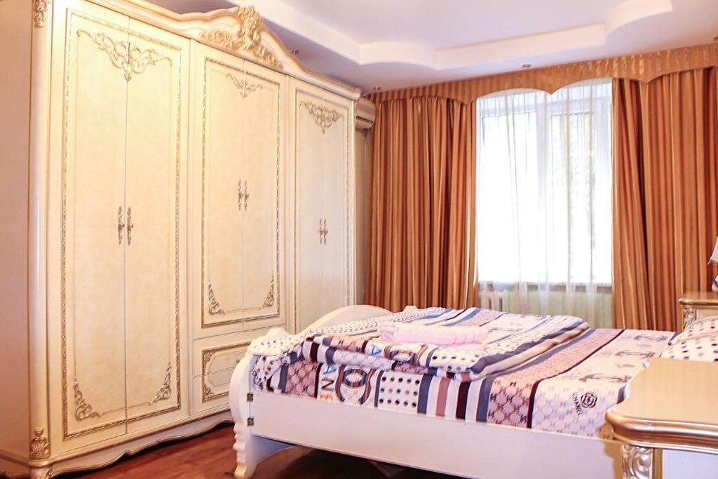 阿拉木图Tolebaeva 65的一间卧室配有一张床和一个大型橱柜