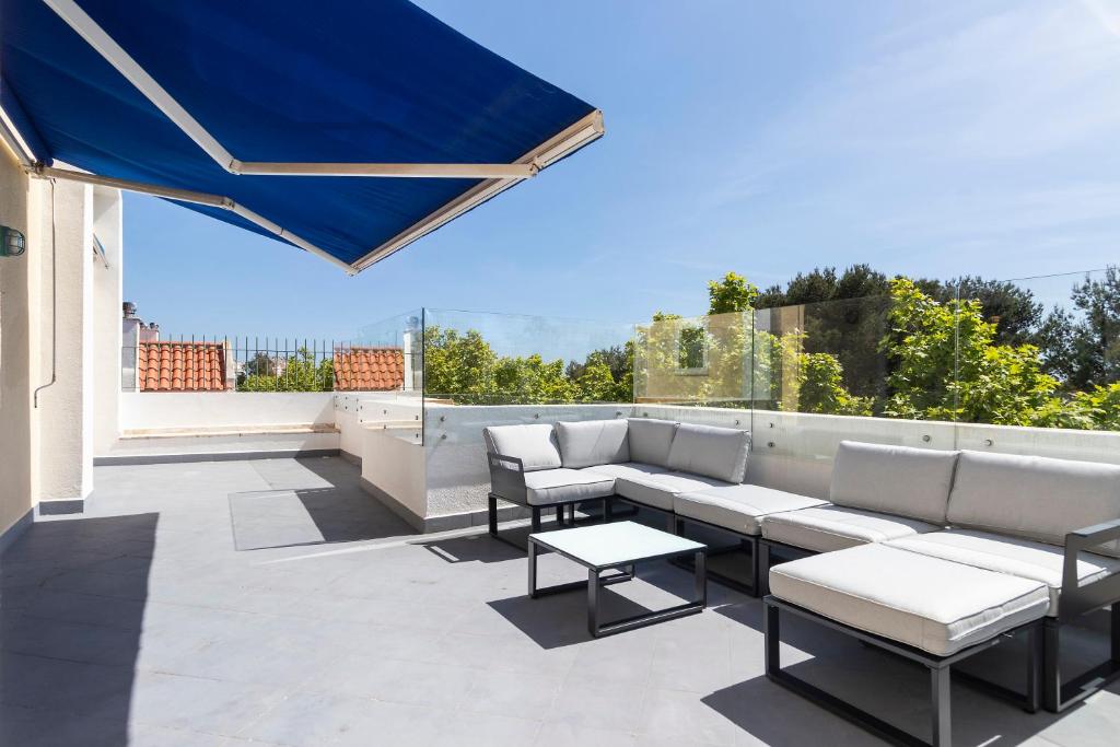 卡斯卡伊斯Cascais Duplex Apartment的屋顶上带沙发和桌子的庭院