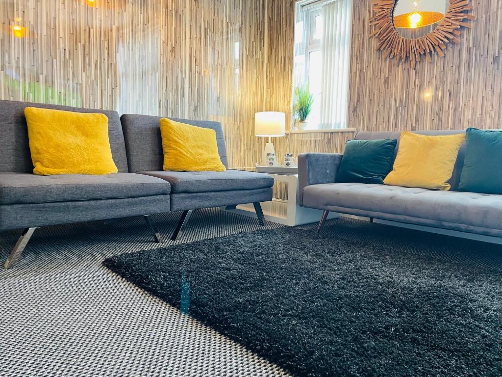 霍利韦尔Holywell Apartment - Luxury One Bedroom Apartment的客厅配有2张蓝色沙发和黄色枕头