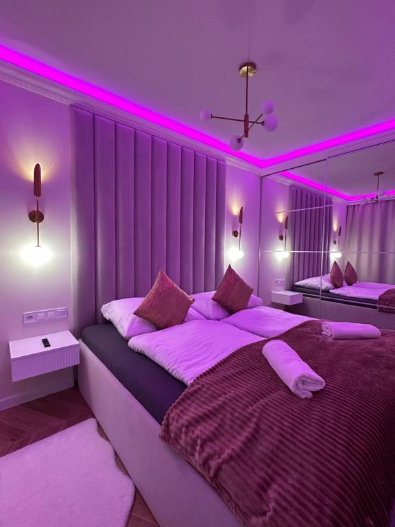斯维诺乌伊希切Apartments Ostsee Suntowers的一间卧室配有两张粉红色照明床