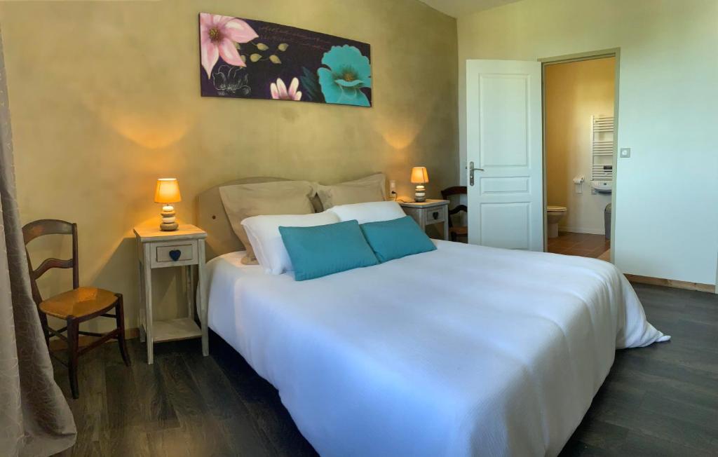 TerraubeMaison du bonheur的卧室配有一张带两个蓝色枕头的大白色床