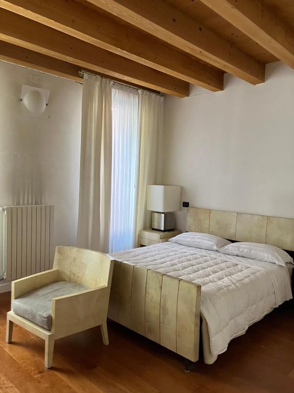 帕多瓦Ciao Amore的一间卧室配有一张大床和一把椅子