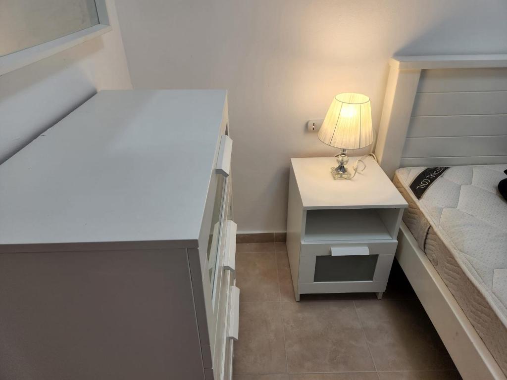 里雄莱锡安city holiday的一间小卧室,配有一张床和一张带台灯的桌子
