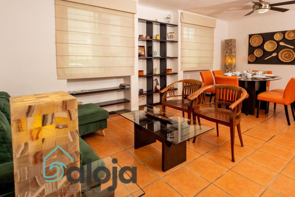 坎昆Apartamento amplio en zona ideal a 5min de WALLMART的客厅配有沙发、椅子和桌子