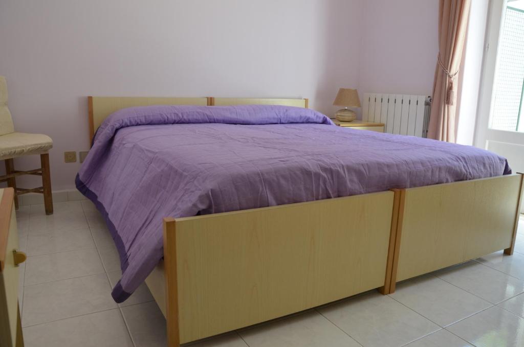 伊斯基亚U农村人旅馆的卧室内的一张带紫色棉被的床
