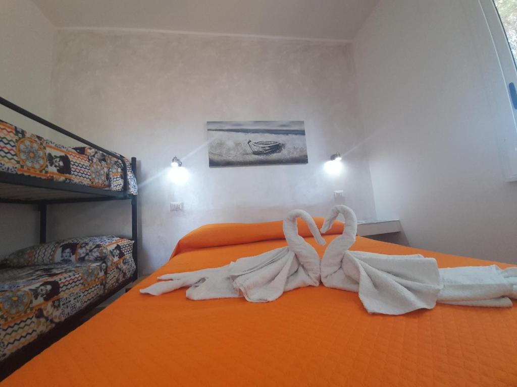 弗卡诺Vulcano: La Porta Delle Eolie的橙色的床,两只天鹅用毛巾制成