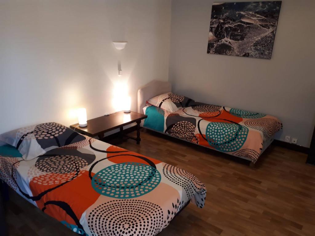 拉罗谢尔Maison de vacances familiale的一间设有两张床和一张桌子的房间