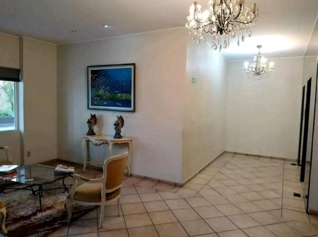戈亚尼亚Apartamento Aconchegante SETOR OESTE的客厅配有桌子和吊灯