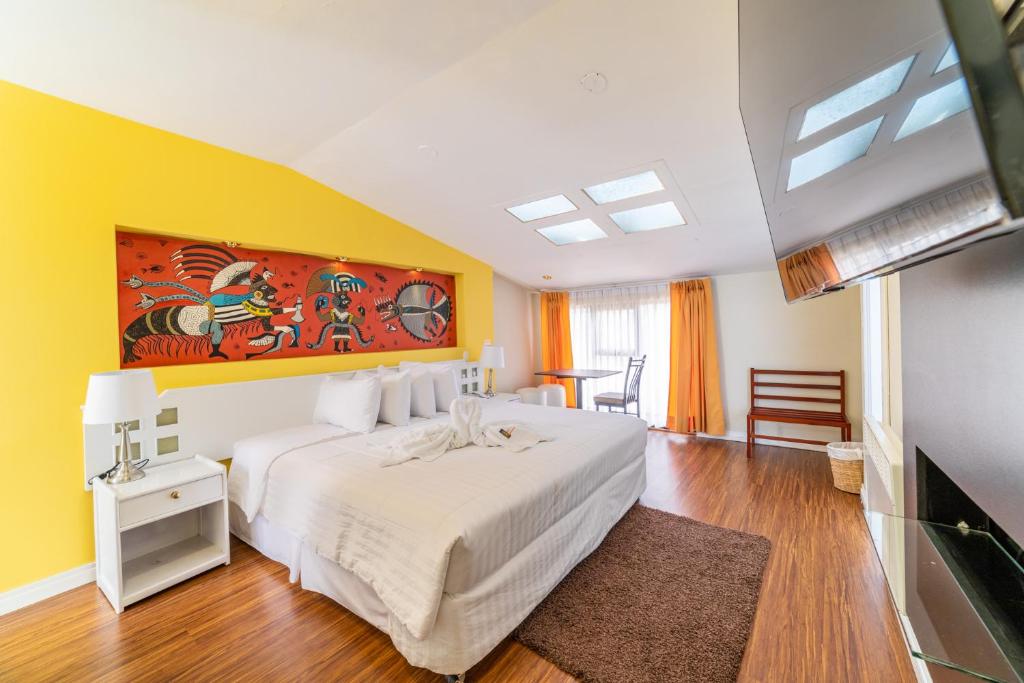 普诺Hotel Qalasaya的卧室配有白色的床和黄色的墙壁