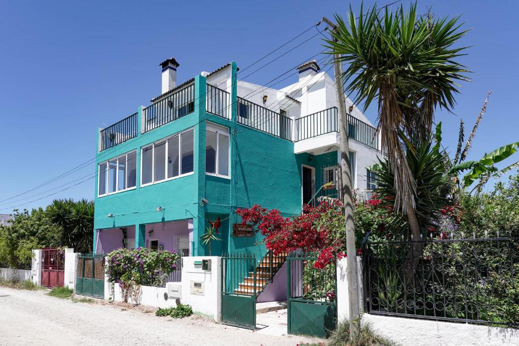 卡帕里卡海岸Natural Mystic Hostel的棕榈树的蓝色和白色房子