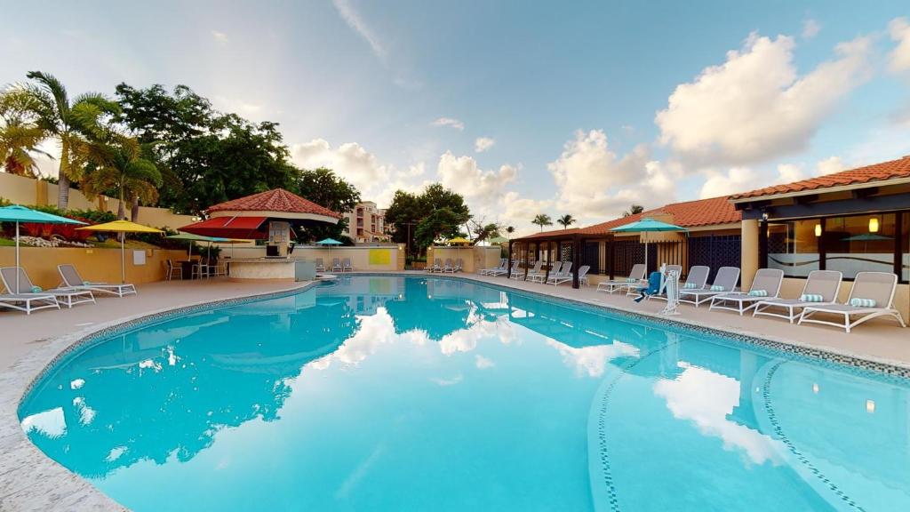 乌马考Park Royal Homestay Club Cala Puerto Rico的一个带椅子和遮阳伞的大型蓝色游泳池