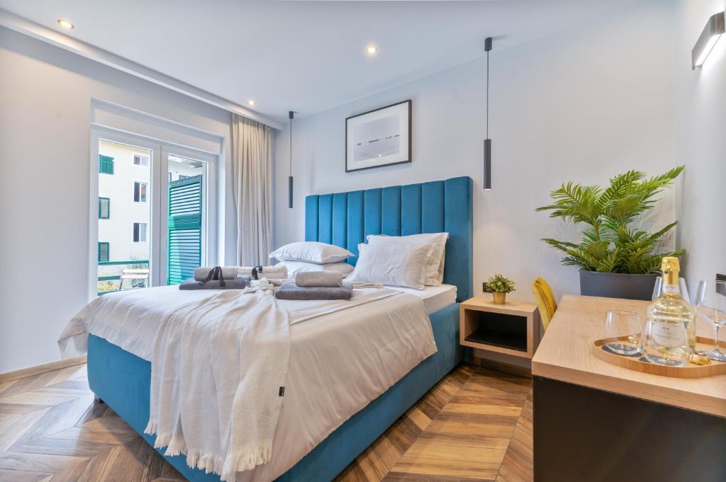 斯普利特West Coast Deluxe Rooms - Vacation Rental的窗户客房内的一张蓝色的床