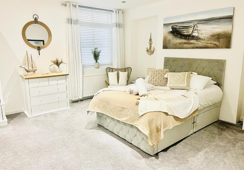 朴次茅斯Seafront Apartment的一间卧室配有一张床、镜子和窗户