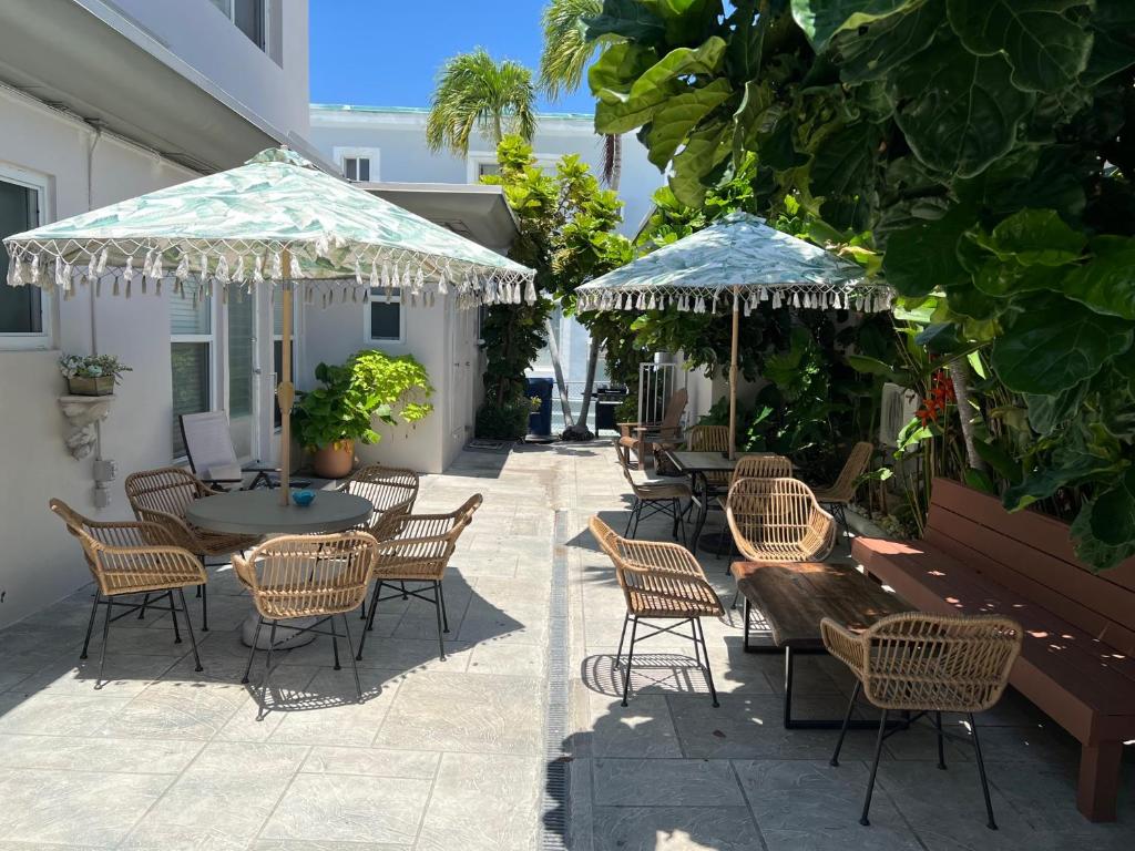 好莱坞海滩Tiana Beach Inn的一个带桌椅和遮阳伞的庭院