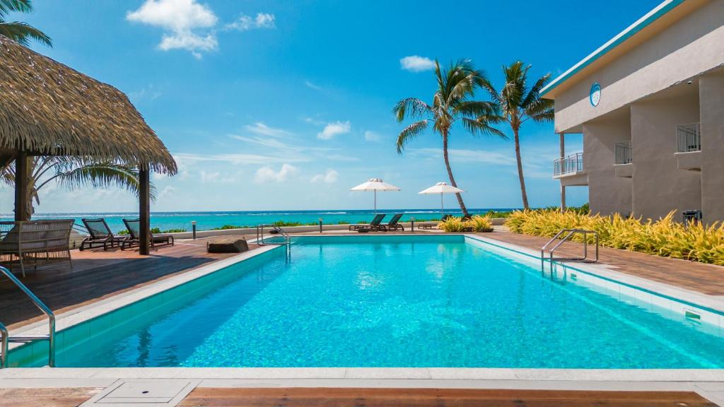 拉罗汤加Moana Sands Lagoon Resort - Adults Only的一座背景海洋的游泳池