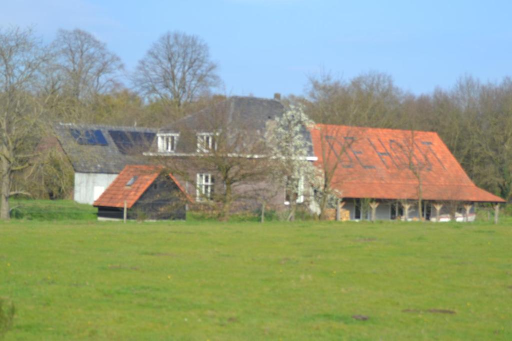SwalmenHouterhoeve的一座位于田野的红色屋顶的旧房子