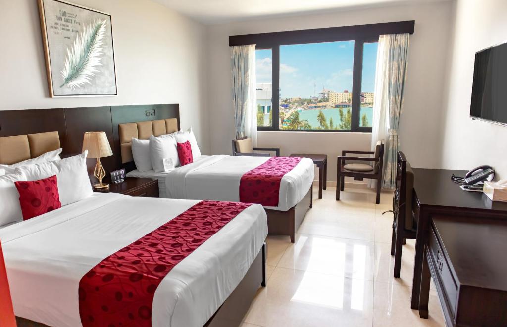 伯利兹城Golden Bay Belize Hotel的酒店客房设有两张床和电视。
